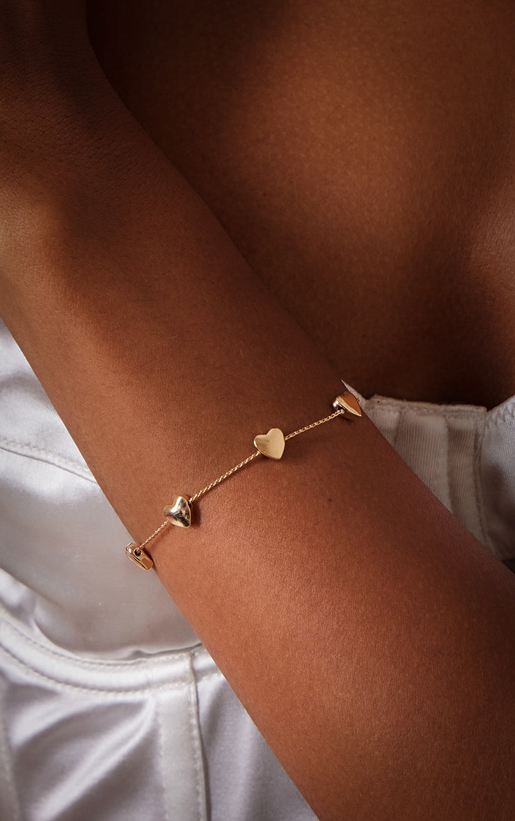 https://cdn-img.prettylittlething.com/0/8/b/9/08b9ff497a206eee89a8d71cb4755f5dd75d6689_CNI2355_1_gold_heart_detail_bracelet.jpg